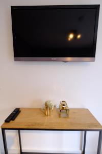 een houten tafel met een televisie aan de muur bij Citycenter Residence in Amsterdam