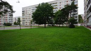 un parco verde con alberi di fronte a un edificio di Sunny Ventspils 7 a Ventspils