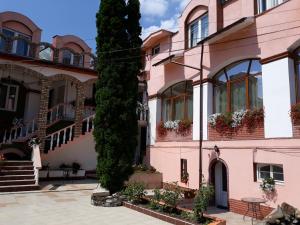 Pensiunea Casa Rusu في بايا ماري: مبنى وردي مع علب الزهور على النوافذ
