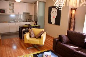 salon z kanapą i krzesłem oraz kuchnia w obiekcie RESIDENCIAL MONDARIZ BALNEARIO 123 w mieście Mondariz-Balneario