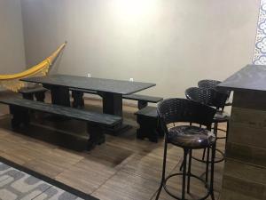 a table with chairs and a bench in a room at Recanto Lili in Olímpia