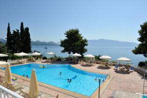 a large swimming pool with people in the water at Porto Galini Seaside Resort & Spa in Nikiana