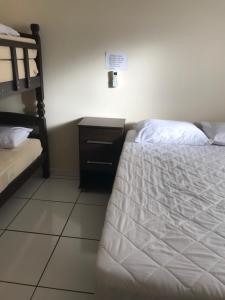 a bedroom with a bed and a dresser with a bed sqor at Recanto Lili in Olímpia +22 photos
