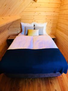 duże łóżko w pokoju z drewnianymi ścianami w obiekcie Domki letniskowe Azalia w mieście Ustronie Morskie