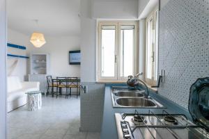 a kitchen with a sink and a living room at Andrew'S home - Playita in Torre Pali