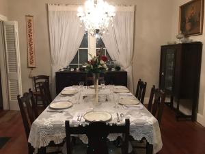 a dining room table with a vase of flowers on it at Riverboat Bed & Breakfast in Natchez