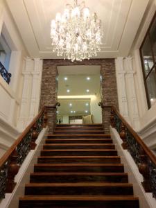 a staircase with a chandelier in a building at Ciudad Fernandina Hotel in Vigan