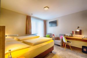 a hotel room with two beds and a desk at Hotel Azenberg in Stuttgart +48 photos