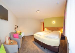 een hotelkamer met een bed en een stoel bij Hotel Azenberg in Stuttgart