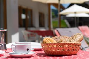 a table with a basket of bread and a cup of coffee at Residence Barbara in Colfosco