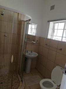 a bathroom with a toilet and a sink at Abendruhe Guest House in Eshowe