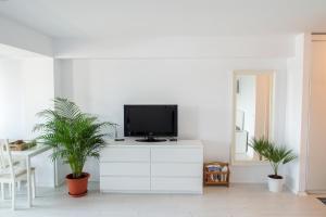 a living room with a tv on a white dresser at Airport Residence - 5 Mins from Airport in Otopeni