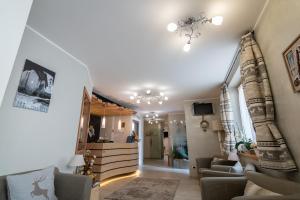 een woonkamer met een bank en een kroonluchter bij Aparthotel Dolomites Living&Relax in Commezzadura
