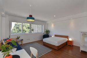 a bedroom with a bed and a living room at Porto Republica Flat in Porto
