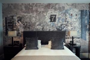 a bedroom with a bed with two lamps and a wall at Malmaison Liverpool in Liverpool