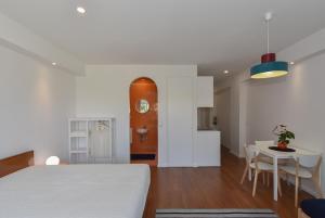 a room with a bed and a table and a kitchen at Porto Republica Flat in Porto