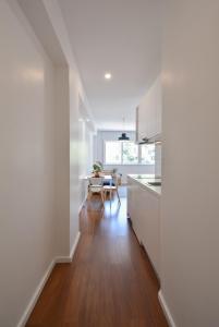 a kitchen and dining room with white cabinets and a table at Porto Republica Flat in Porto