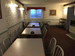 a dining room with tables and chairs and a window at DC Lodge in Dawson Creek +9 photos