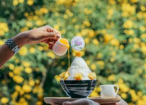 a person pouring tea into a bowl of food at Wangyao Riverside Resort in Ban Khlong Bo