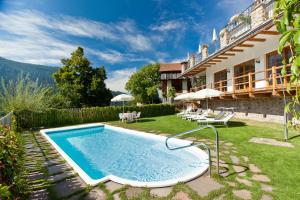 - une piscine extérieure dans la cour d'une maison dans l'établissement Alpinhotel Vajolet - Adults only, à Tires