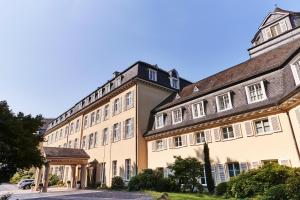 un gran edificio bronceado con techo marrón en Steigenberger Grandhotel & Spa Petersberg en Königswinter