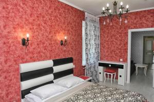 a bedroom with red walls and a bed and a desk at Apartment on Malaya Troitskaya 13 in Grodno