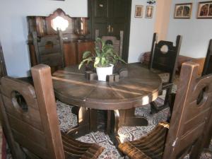uma mesa de jantar em madeira com um vaso de plantas em Kastélyfogadó Sitke em Sitke
