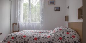 - une chambre avec un lit doté d'une couverture en point de polka dans l'établissement Les Hortensias, à Millas