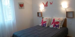 1 dormitorio con 1 cama con mariposas en la pared en Les Hortensias en Millas