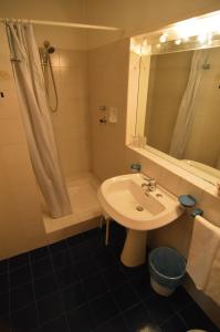 een badkamer met een wastafel, een douche en een spiegel bij Albergo Ristorante Della Torre in Trescore Balneario