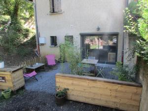 - un jardin avec une table et des chaises en face d'un bâtiment dans l'établissement chez karine et julie, à La Rochette