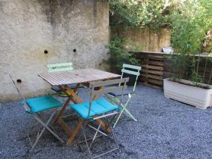 une table et des chaises assises à côté d'un mur dans l'établissement chez karine et julie, à La Rochette