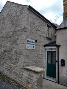 
a stone building with a sign on the side of it at The Stables Guest Apartment in Cookstown
