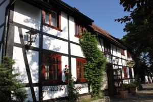 a black and white building with red windows at Fisherman's House in Ustka