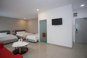 Habitación de hotel con 2 camas y TV de pantalla plana. en Twenty Nine Hotel, en Yong Peng