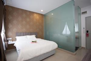 1 dormitorio con 1 cama blanca grande y pared de cristal en Twenty Nine Hotel, en Yong Peng