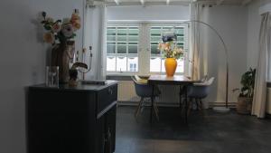 a kitchen with a table and a vase of flowers at La vita e bella in Ootmarsum