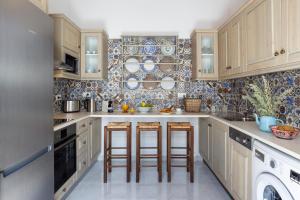 a kitchen with wooden cabinets and bar stools at Lindos Vista Luxury Villa in Lindos