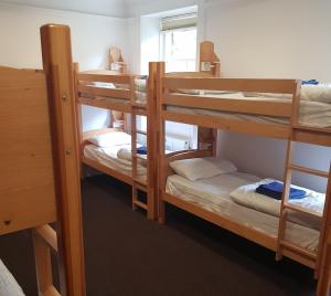 a room with three bunk beds in a dorm at Lochranza Youth Hostel in Lochranza