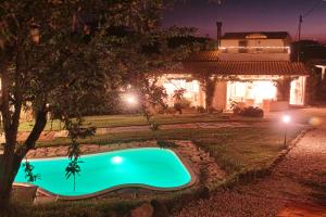 a swimming pool in front of a house at night at Villa Tamara Country & Spa Suites in Montefiore Conca