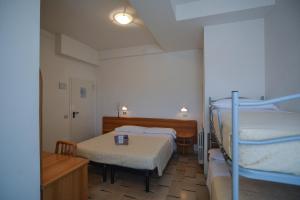 a room with two bunk beds and a table at Hotel Zani in Cervia