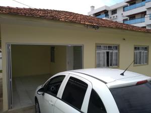 un coche blanco estacionado frente a un garaje en Casa 6 pessoas 100m do mar 010, en Florianópolis