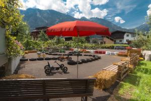 a red umbrella in a parking lot with a scooteritures at Apart Central – Premium Mountain&Garden in Mayrhofen