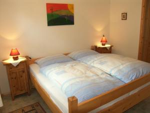 a bedroom with a bed with two lamps on night stands at Espi-Stables Ferienhof Esterhammer in Liebenau