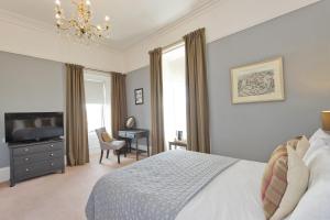 a bedroom with a bed and a desk and a chair at Greenland house in Castletown