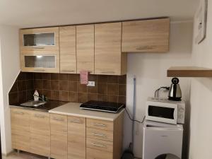 una pequeña cocina con armarios de madera y microondas en Apartmán Zebra, en Ružomberok