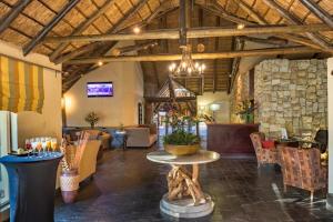 a lobby with a table in the middle of a room at Shumba Valley Lodge in Lanseria