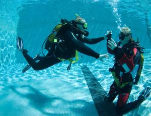two people in the water playing with a net at Dom Pedro Madeira in Machico