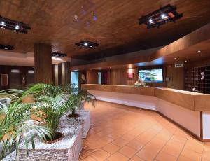 a lobby with a waiting area with plants in it at Dom Pedro Madeira in Machico
