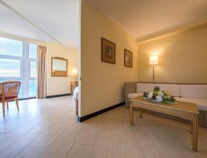 a living room with a couch and a table at Dom Pedro Madeira in Machico